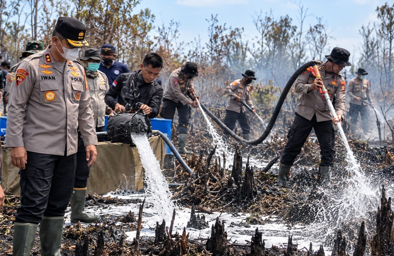 Personel Polda Kalteng menyemprotkan cairan X-Fire untuk memadamkan bara api di lahan gambut Jalan Manduhara, Palangka Raya.