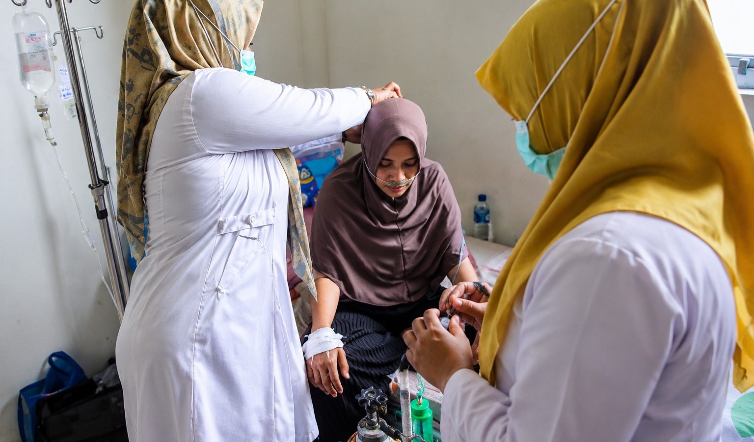 Tenaga kesehatan memasang selang oksigen untuk membantu pernapasan pasien yang mengalami Infeksi Saluran Pernapasan Akut (ISPA) di ruang perawatan.