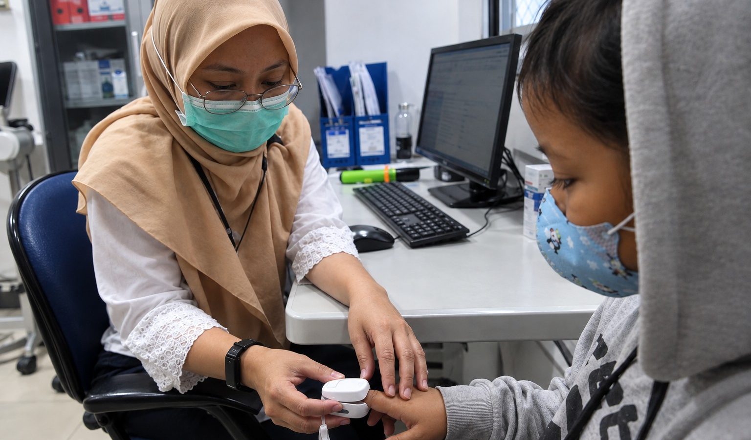 Tenaga kesehatan memeriksa kondisi ISPA dan kesehatan seorang anak di ruang pemeriksaan.