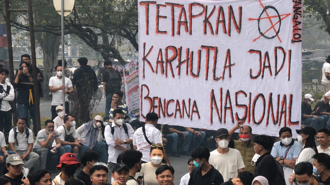 Mahasiswa membentangkan spanduk bertuliskan “Tetapkan Karhutla Jadi Bencana Nasional” saat menggelar aksi Jilid IV di depan Kantor Gubernur Kalteng, Jumat (23/10/2026).